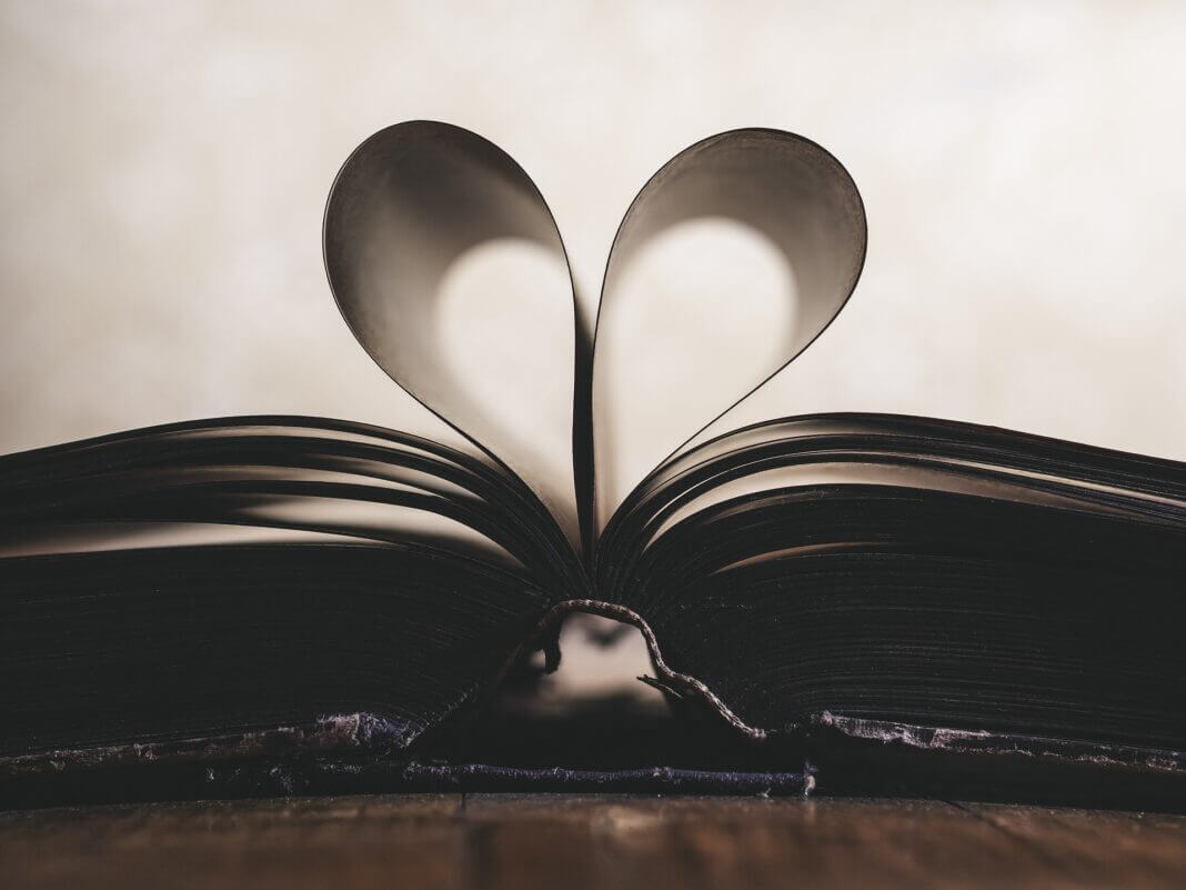 Livro com folhas abertas em formato de coração representando o amor pela leitura, por mensagens inspiradoras, pela palavra de Deus
